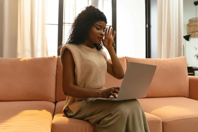 woman on couch using laptop